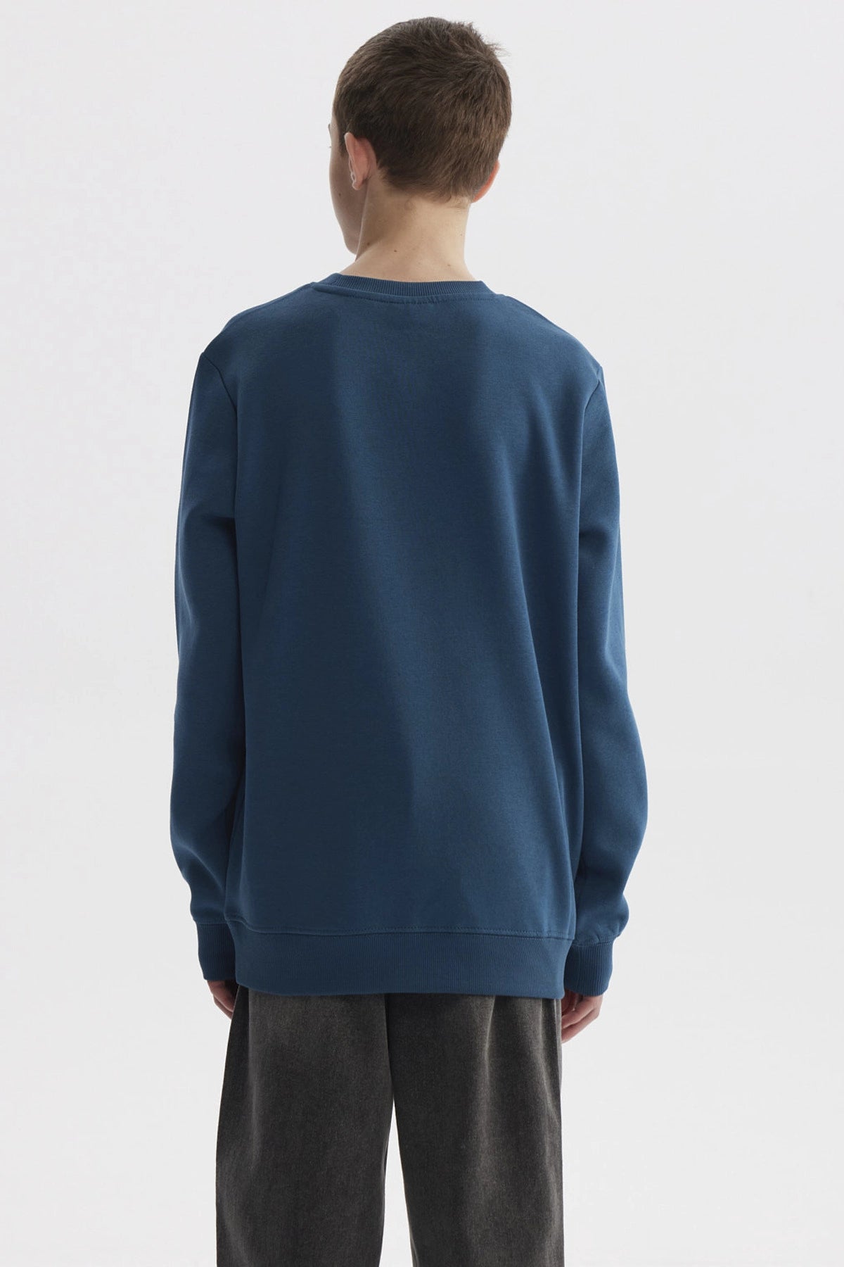 Polerón niño color petróleo con texto SUPER COOL y casco azul al centro en estilo deportivo casual y cómodo