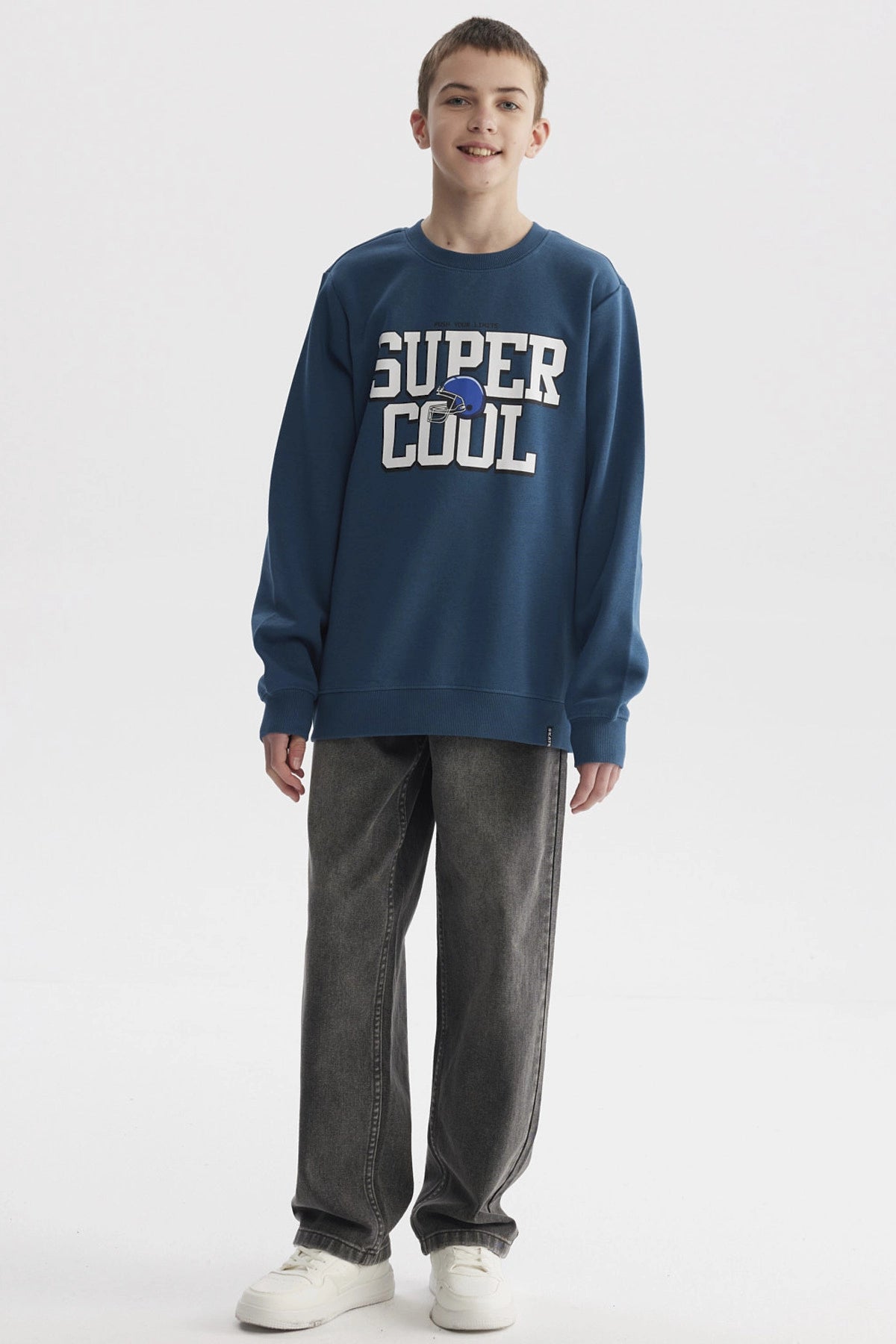 Polerón niño color petróleo con texto SUPER COOL y casco azul al centro en estilo deportivo casual y cómodo