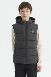 Parka de niño color marengo con gorro acolchado y parche circular en el pecho estilo urbano