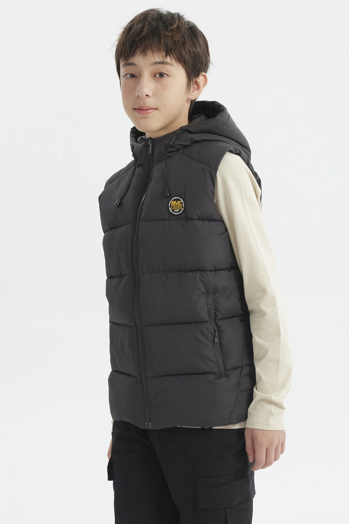 Parka de niño color marengo con gorro acolchado y parche circular en el pecho estilo urbano