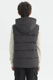 Parka de niño color marengo con gorro acolchado y parche circular en el pecho estilo urbano