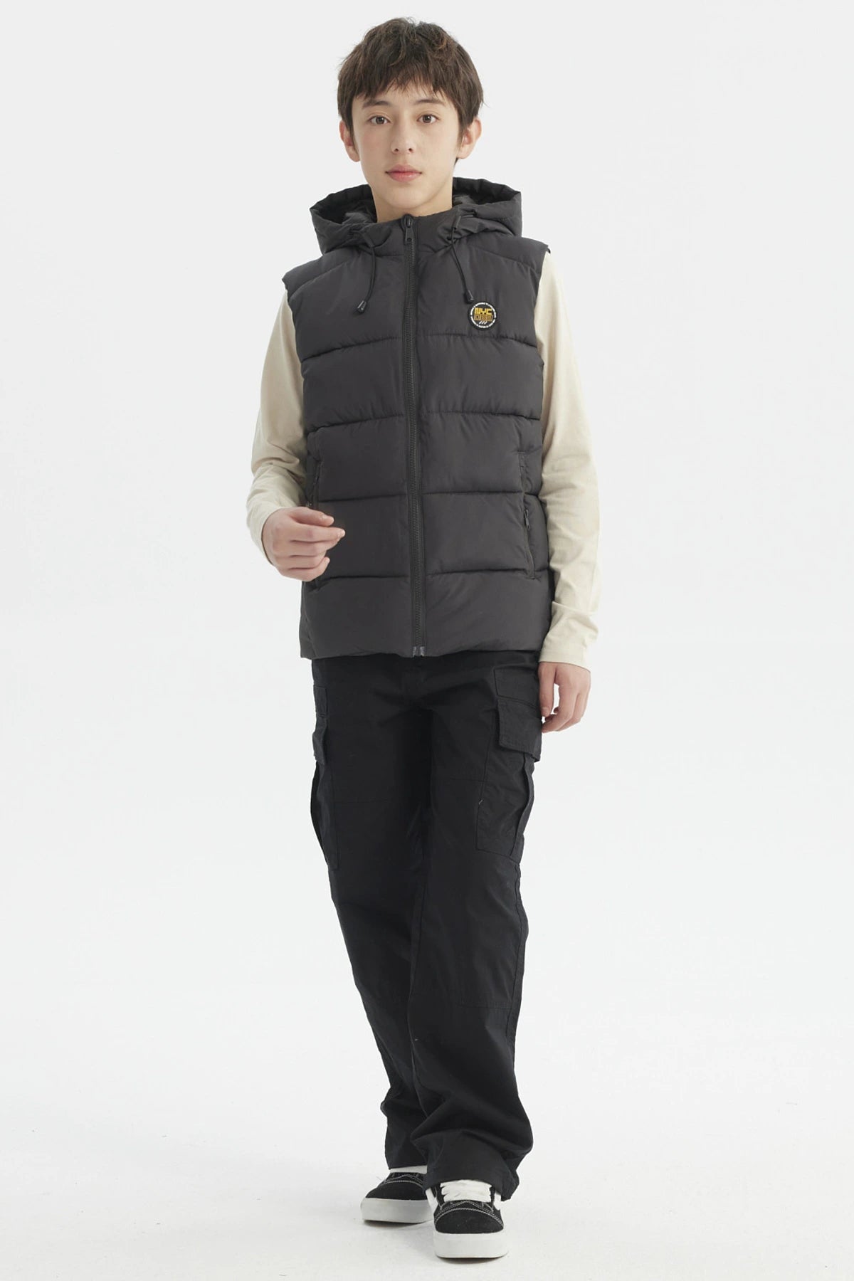 Parka de niño color marengo con gorro acolchado y parche circular en el pecho estilo urbano