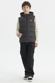 Parka de niño color marengo con gorro acolchado y parche circular en el pecho estilo urbano
