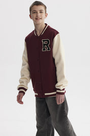 Chaqueta tipo college burdeo para niño con mangas beige y gran letra R en el pecho estilo universitario