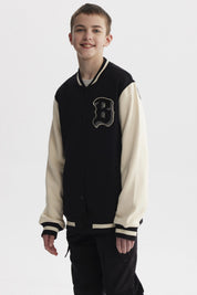 Chaqueta de niño estilo college en negro con mangas beige y letra B grande en el pecho estilo varsity