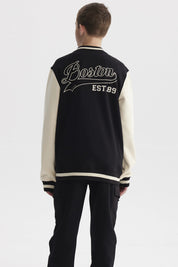 Chaqueta de niño estilo college en negro con mangas beige y letra B grande en el pecho estilo varsity