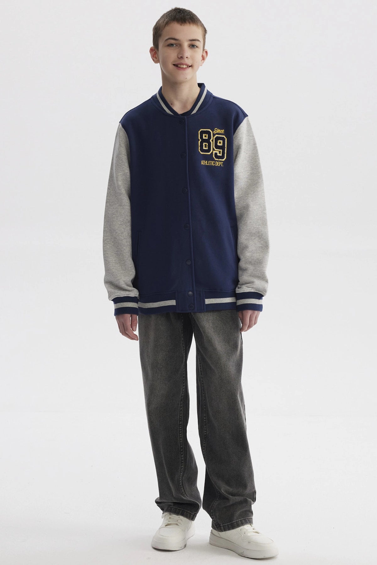 Chaqueta niño azul oscuro estilo college con mangas grises y estampado frontal pequeño de números en el pecho