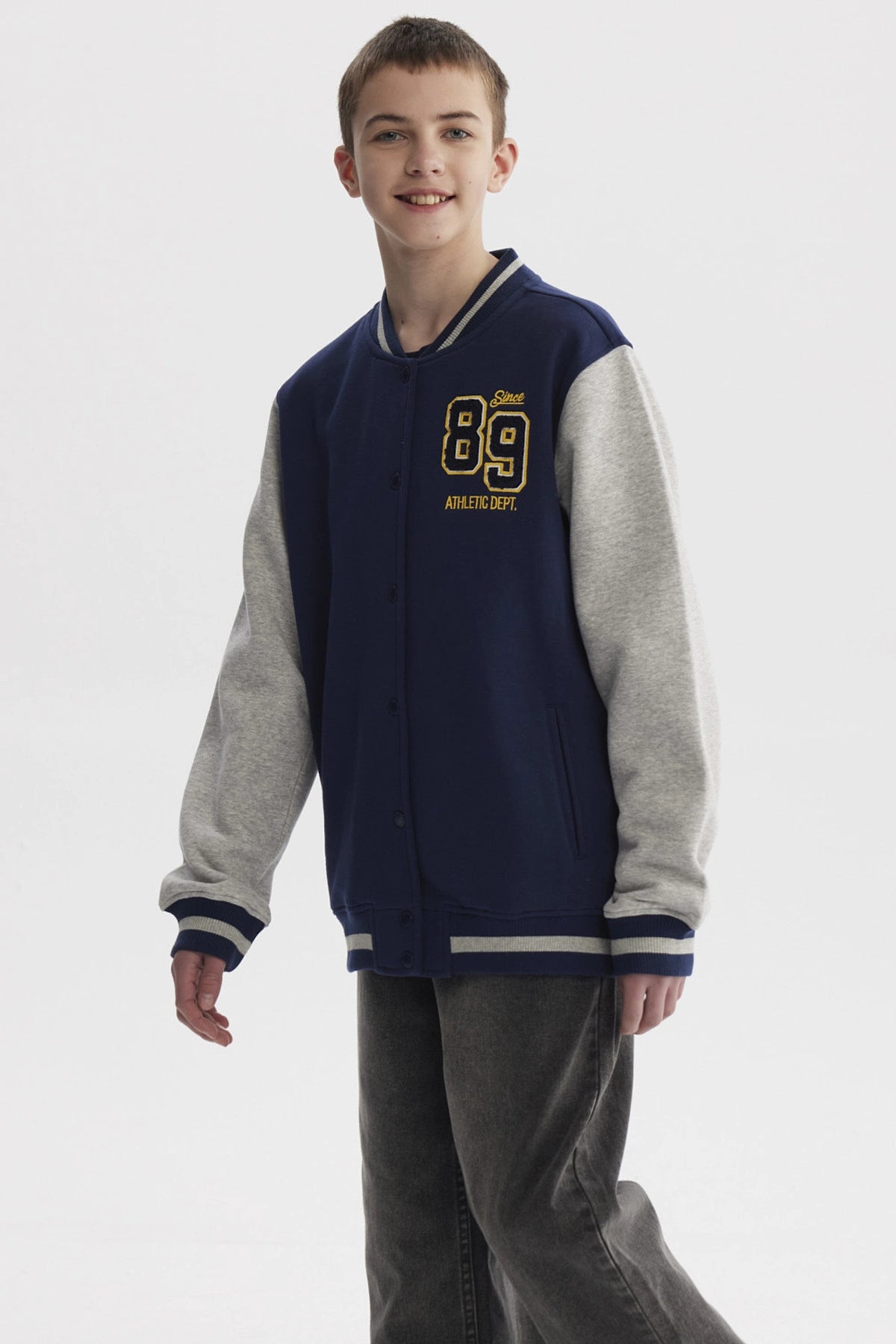 Chaqueta niño azul oscuro estilo college con mangas grises y estampado frontal pequeño de números en el pecho