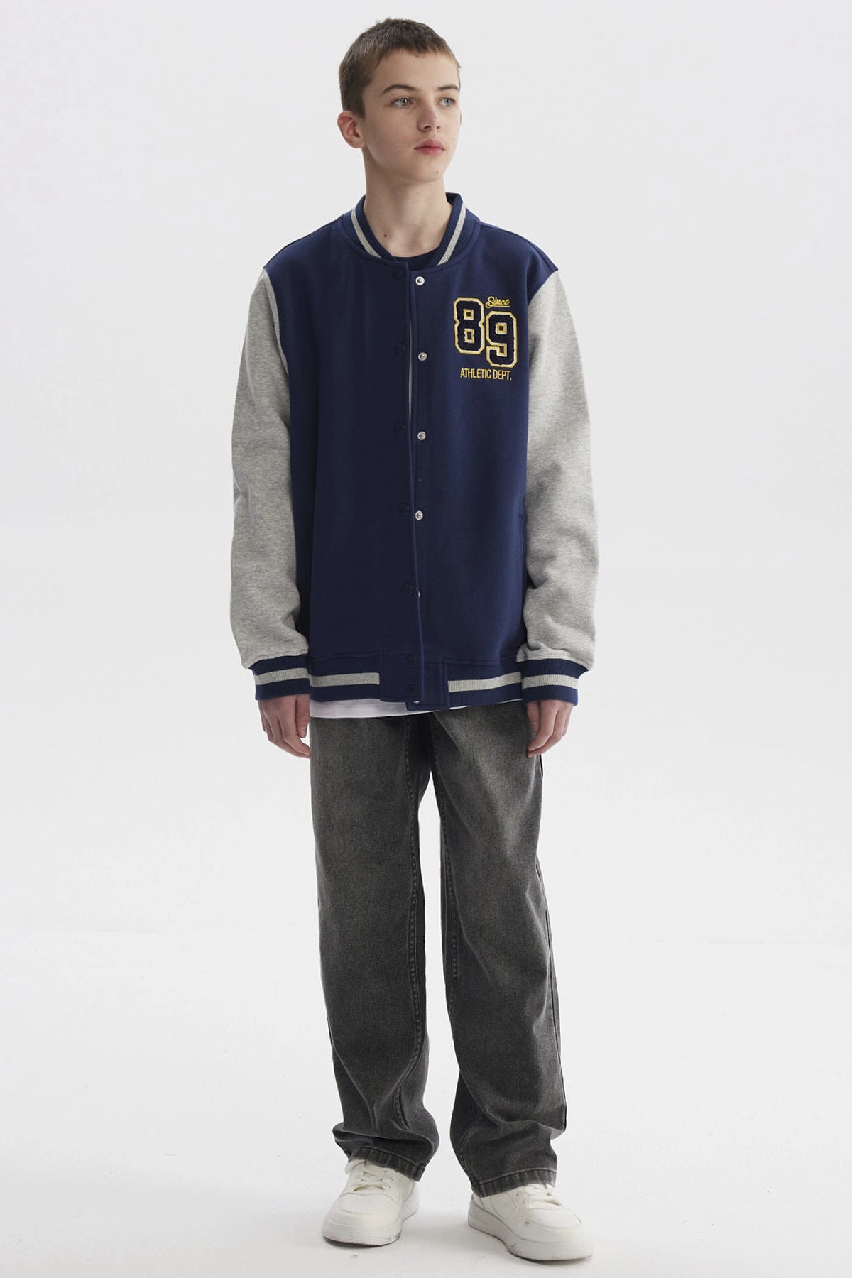 Chaqueta niño azul oscuro estilo college con mangas grises y estampado frontal pequeño de números en el pecho