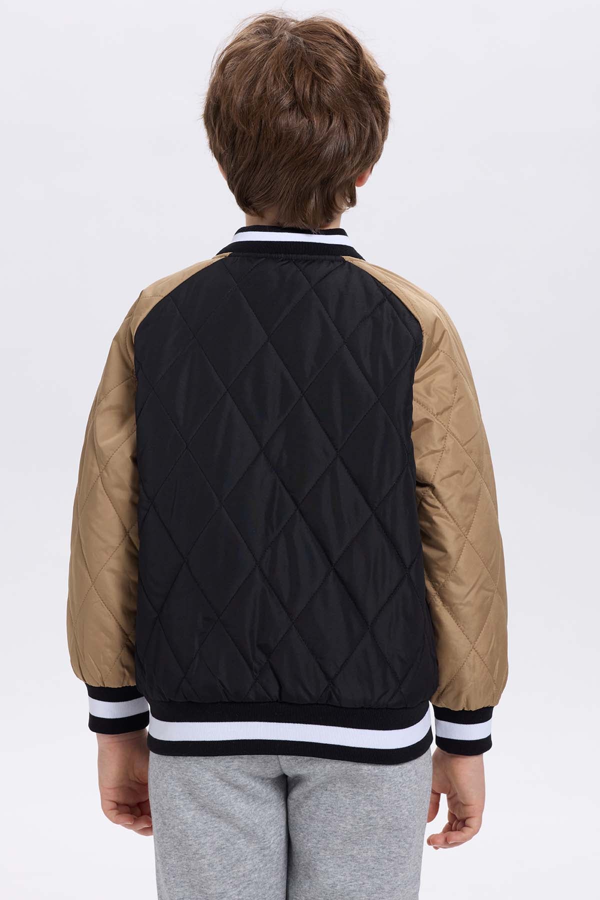 Chaqueta niño bomber negra con mangas beige y bordado