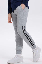 Pantalón buzo niño gris melange con rayas lateral