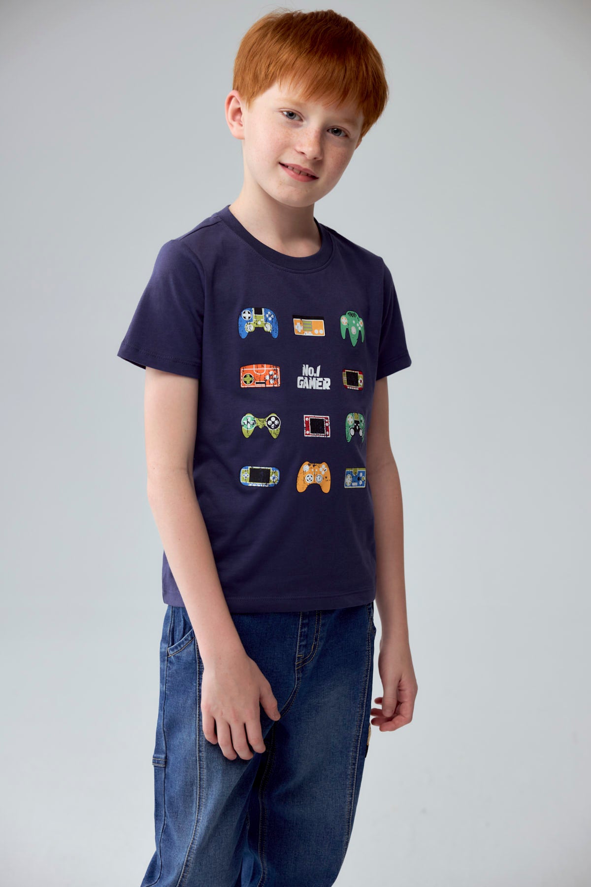 Polera niño azul con estampado de controles de videojuegos variados en el frente