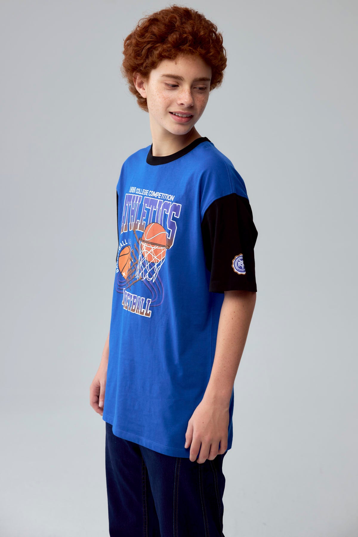 Polera azul con estampado de baloncesto y texto Athletics en el frente