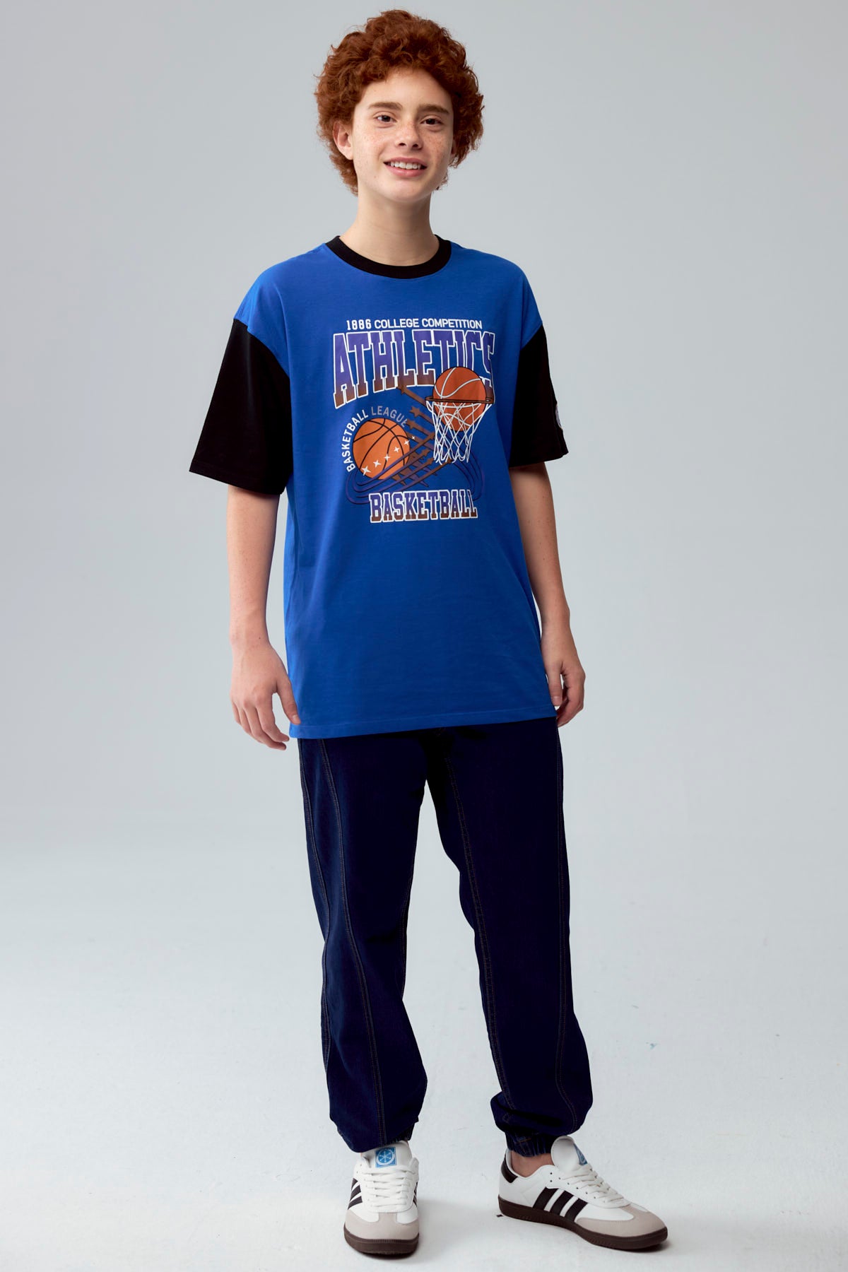 Polera azul con estampado de baloncesto y texto Athletics en el frente