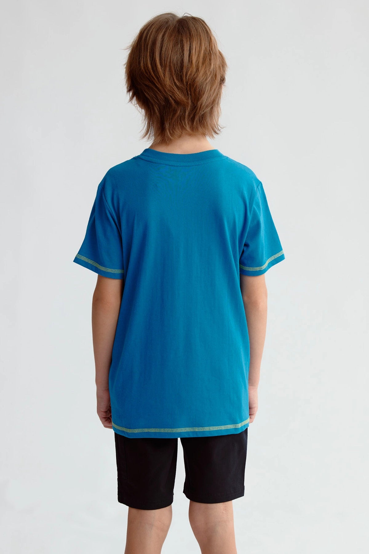 Polera azul de niño con estampado de dinosaurio geométrico y texto Roarsome en el pecho