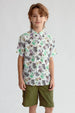 Camisa blanca de niño con estampado de dinosaurios y palmeras