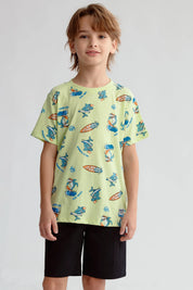 Polera niño verde claro con estampado de surfistas y tablas de surf