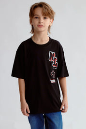 Polera negra con estampado Next Level en el pecho de un niño