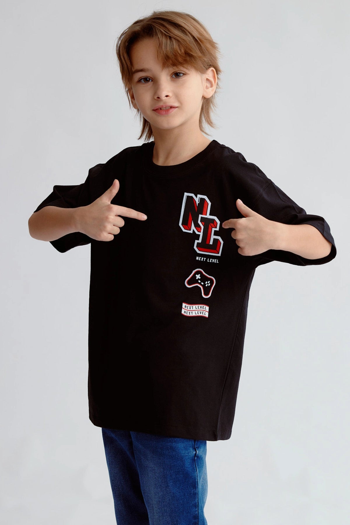 Polera negra con estampado Next Level en el pecho de un niño