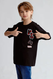 Polera negra con estampado Next Level en el pecho de un niño