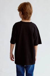 Polera negra con estampado Next Level en el pecho de un niño