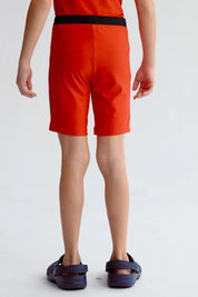 Short de baño niño rojo con cinturilla negra y texto Surf Club en la pierna