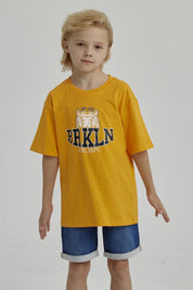 Polera naranjo de niño con estampa de tigre y texto BRKLN al frente en estilo deportivo casual