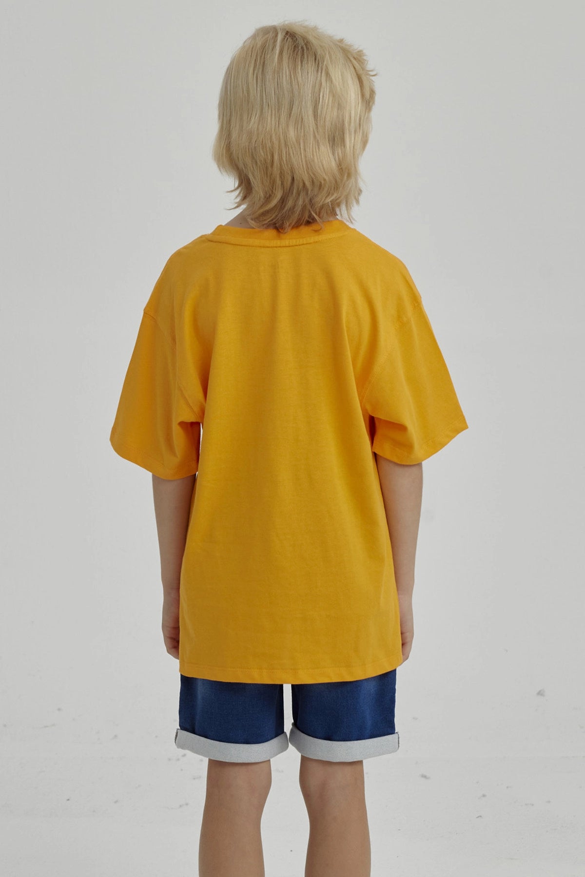 Polera naranjo de niño con estampa de tigre y texto BRKLN al frente en estilo deportivo casual