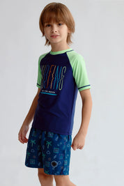 Traje de baño azul oscuro con camiseta de mangas verdes y estampado Surfing en el pecho