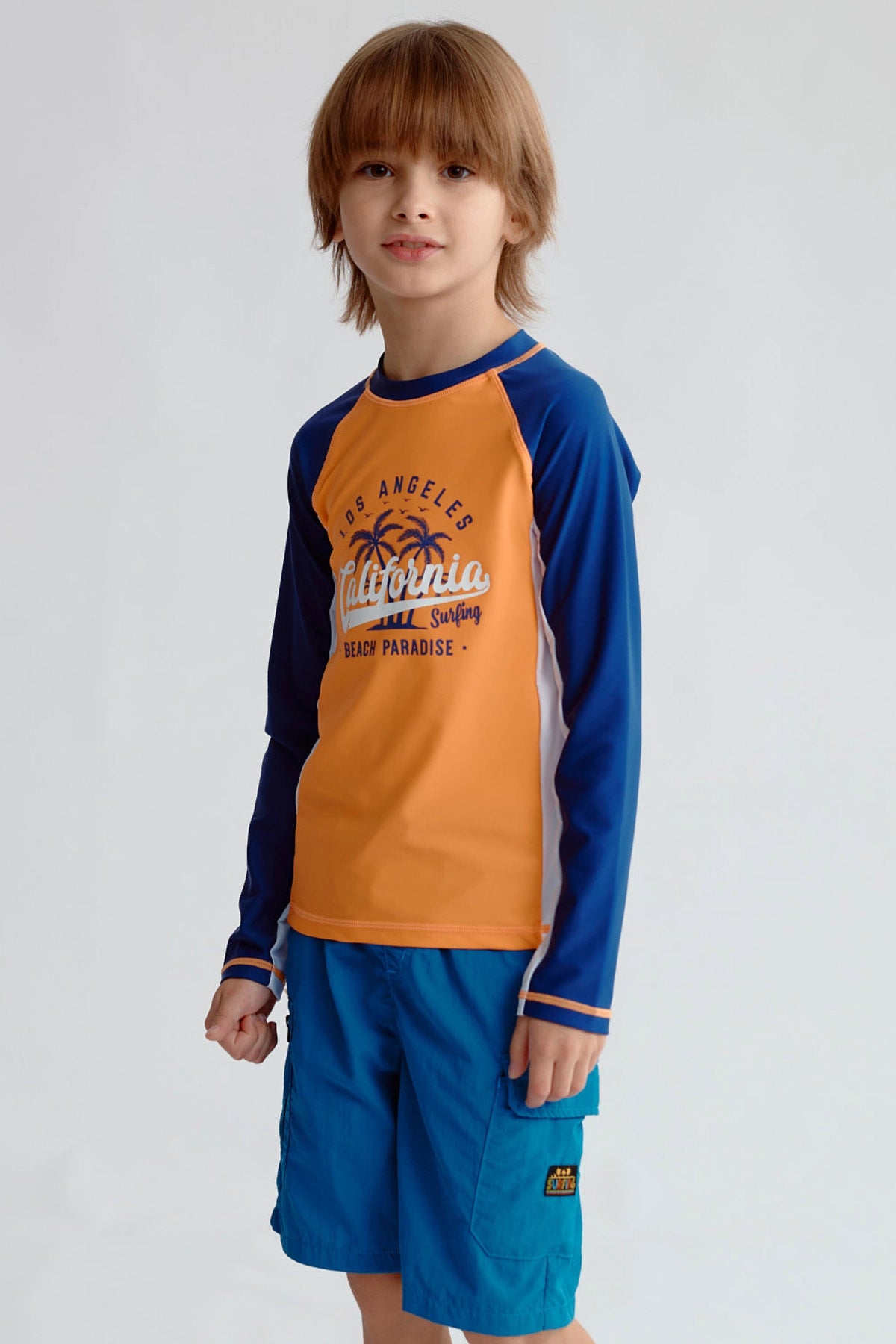 Traje de baño naranjo con mangas azules y diseño de California en el pecho