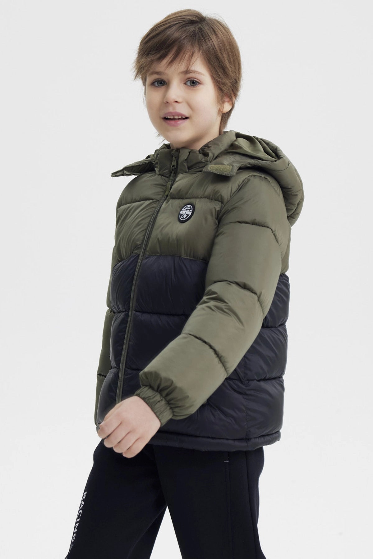 Parka de niño verde militar con capucha cierre frontal y bolsillo con parche en el pecho estampa circular negra