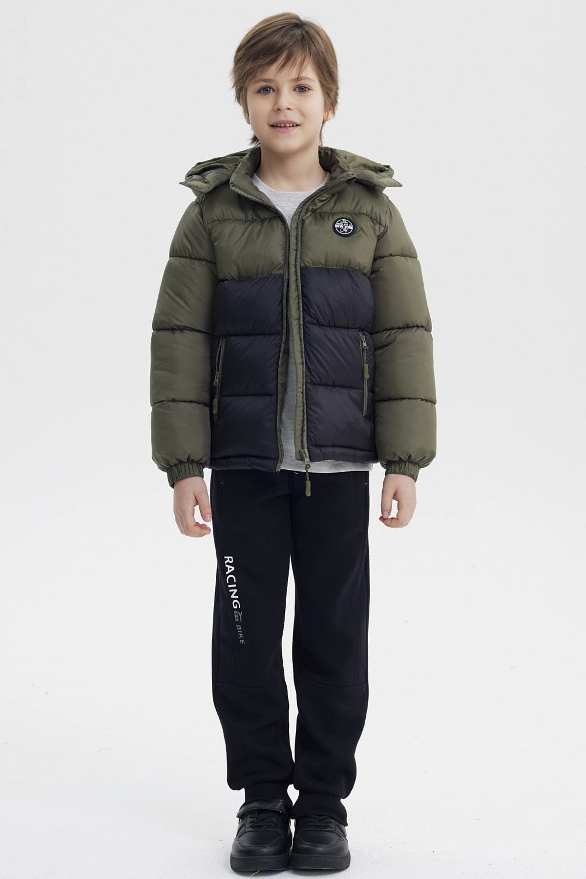 Parka de niño verde militar con capucha cierre frontal y bolsillo con parche en el pecho estampa circular negra