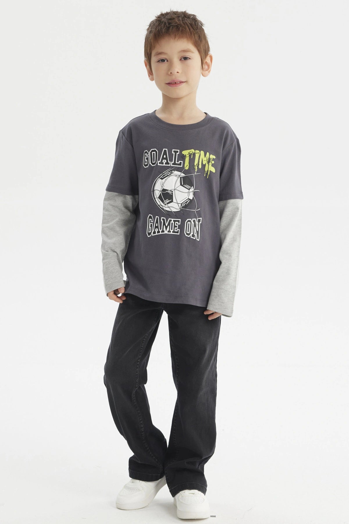 Polera de niño color marengo con estampado delantero de balón de fútbol y texto Goal Time Game On estilo deportivo casual