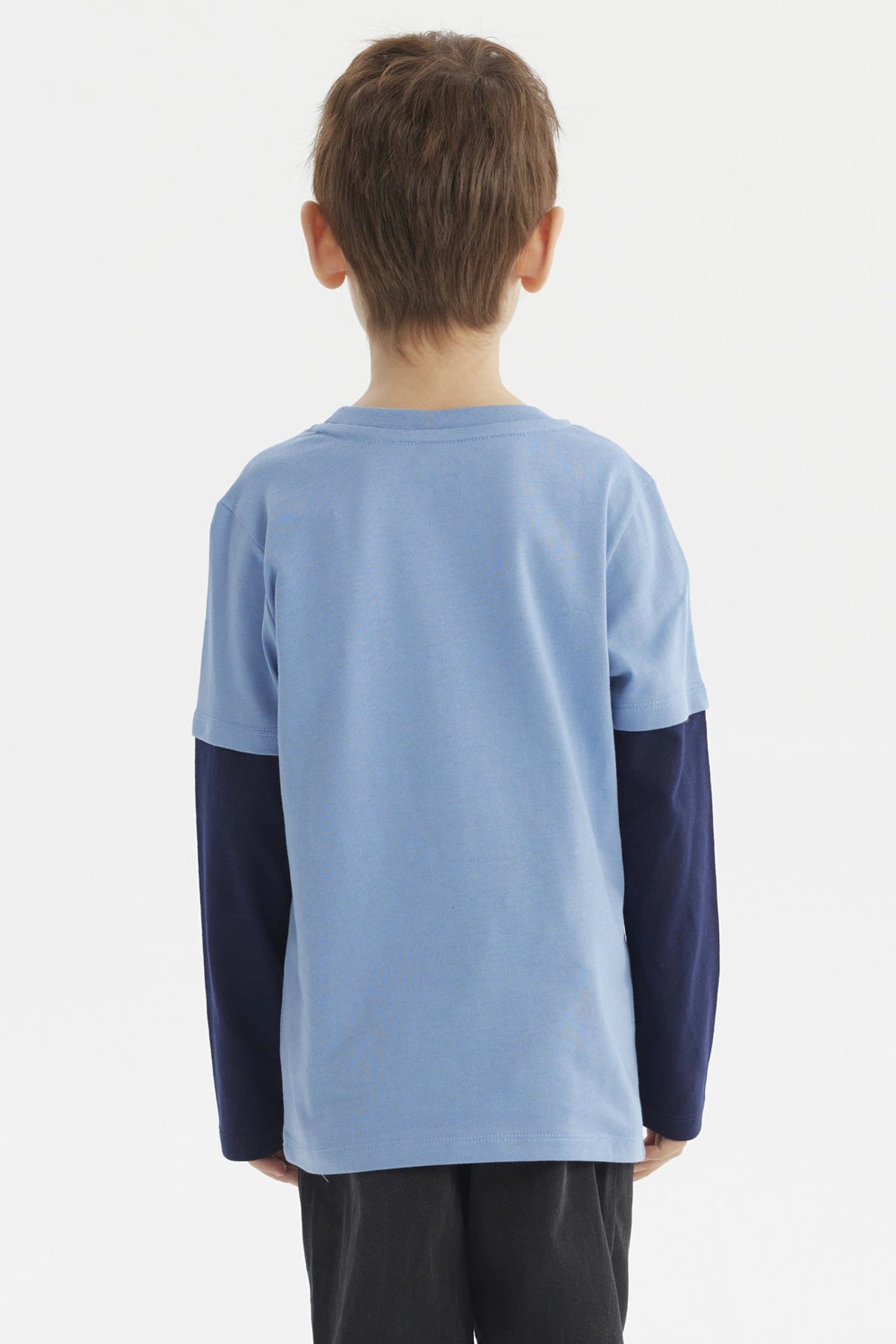 Polera de niño azul claro con diseño de triceratops gráfico al frente estilo ilustración en negro y texto Triceratops