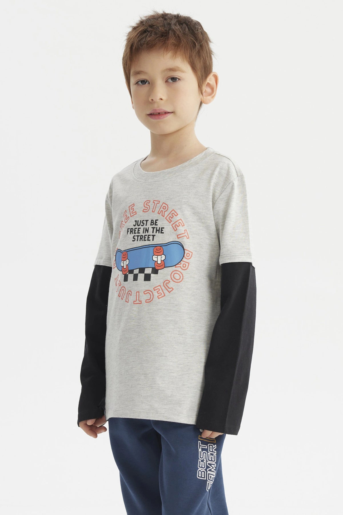 Polera niño gris melange claro con mangas negras y estampado central de skate con texto Free Street estilo urbano