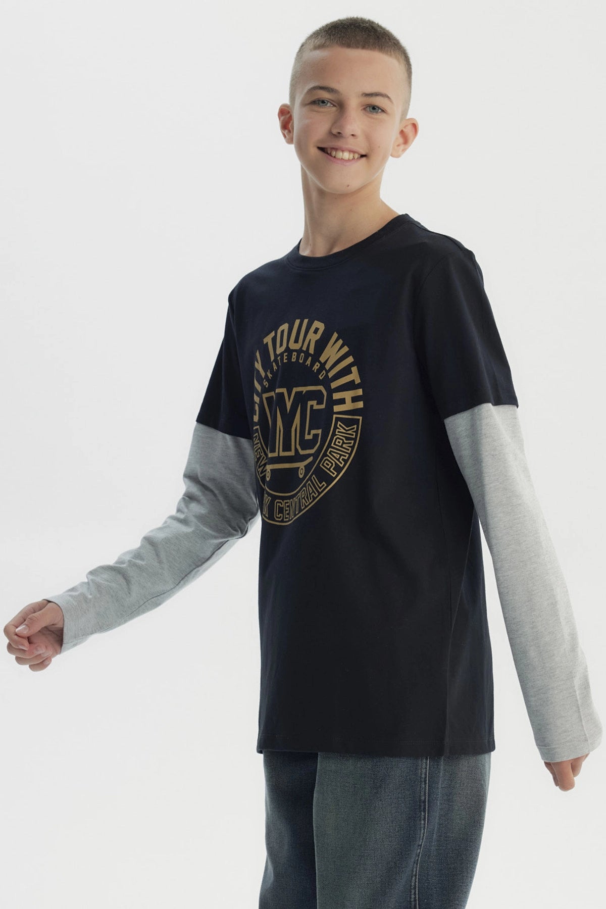 Polera negra para niño con estampado central NYC dorado en letras grandes manga larga gris claro y diseño casual