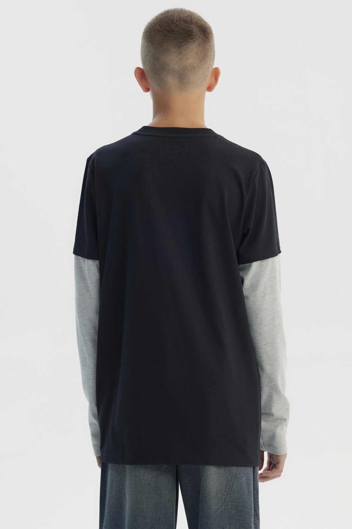 Polera negra para niño con estampado central NYC dorado en letras grandes manga larga gris claro y diseño casual
