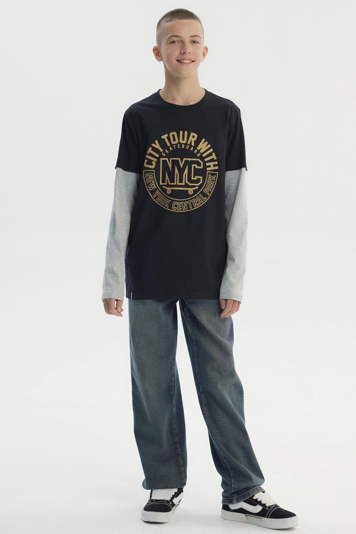Polera negra para niño con estampado central NYC dorado en letras grandes manga larga gris claro y diseño casual