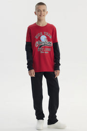Polera niño roja oscura con diseño de casco de fútbol y texto Nice Team Champions en el centro estilo deportivo