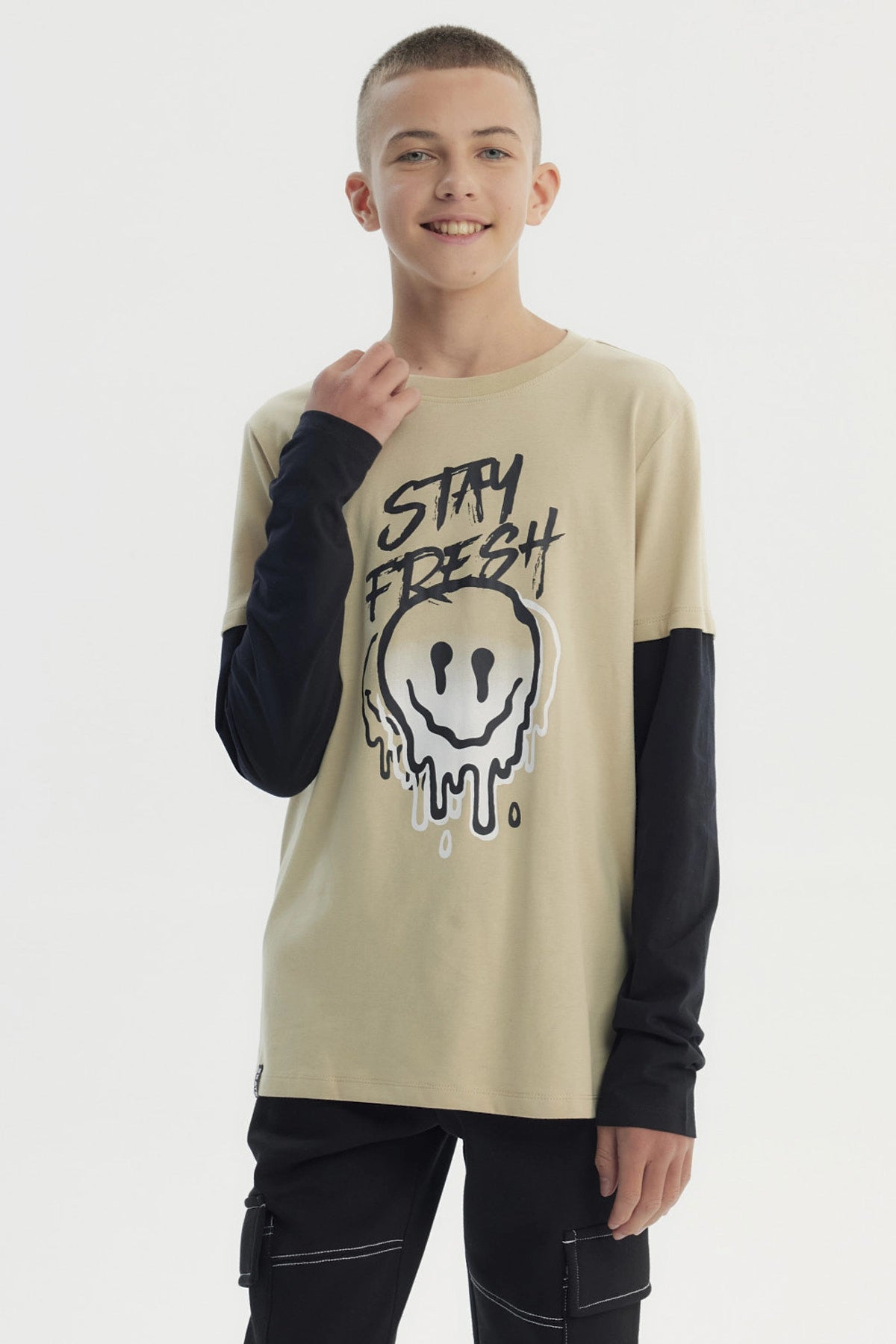 Polera beige para niño con estampa frontal de carita sonriente derretida y texto Stay Fresh estilo urbano