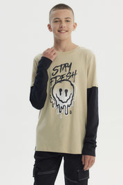 Polera beige para niño con estampa frontal de carita sonriente derretida y texto Stay Fresh estilo urbano