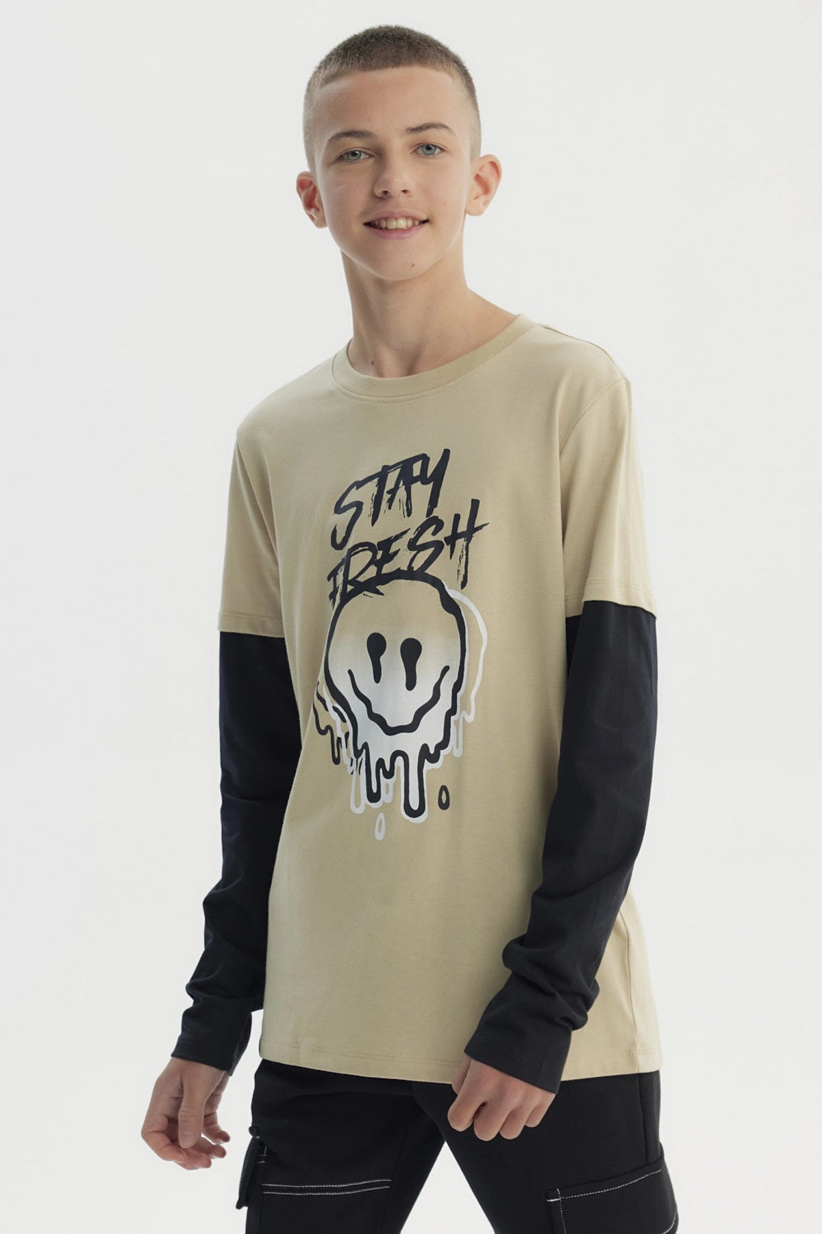 Polera beige para niño con estampa frontal de carita sonriente derretida y texto Stay Fresh estilo urbano