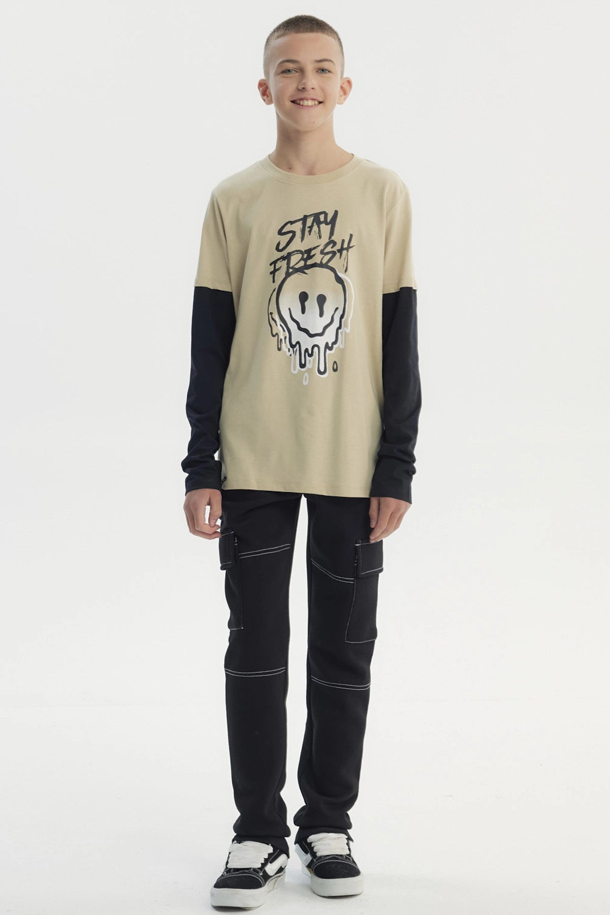Polera beige para niño con estampa frontal de carita sonriente derretida y texto Stay Fresh estilo urbano