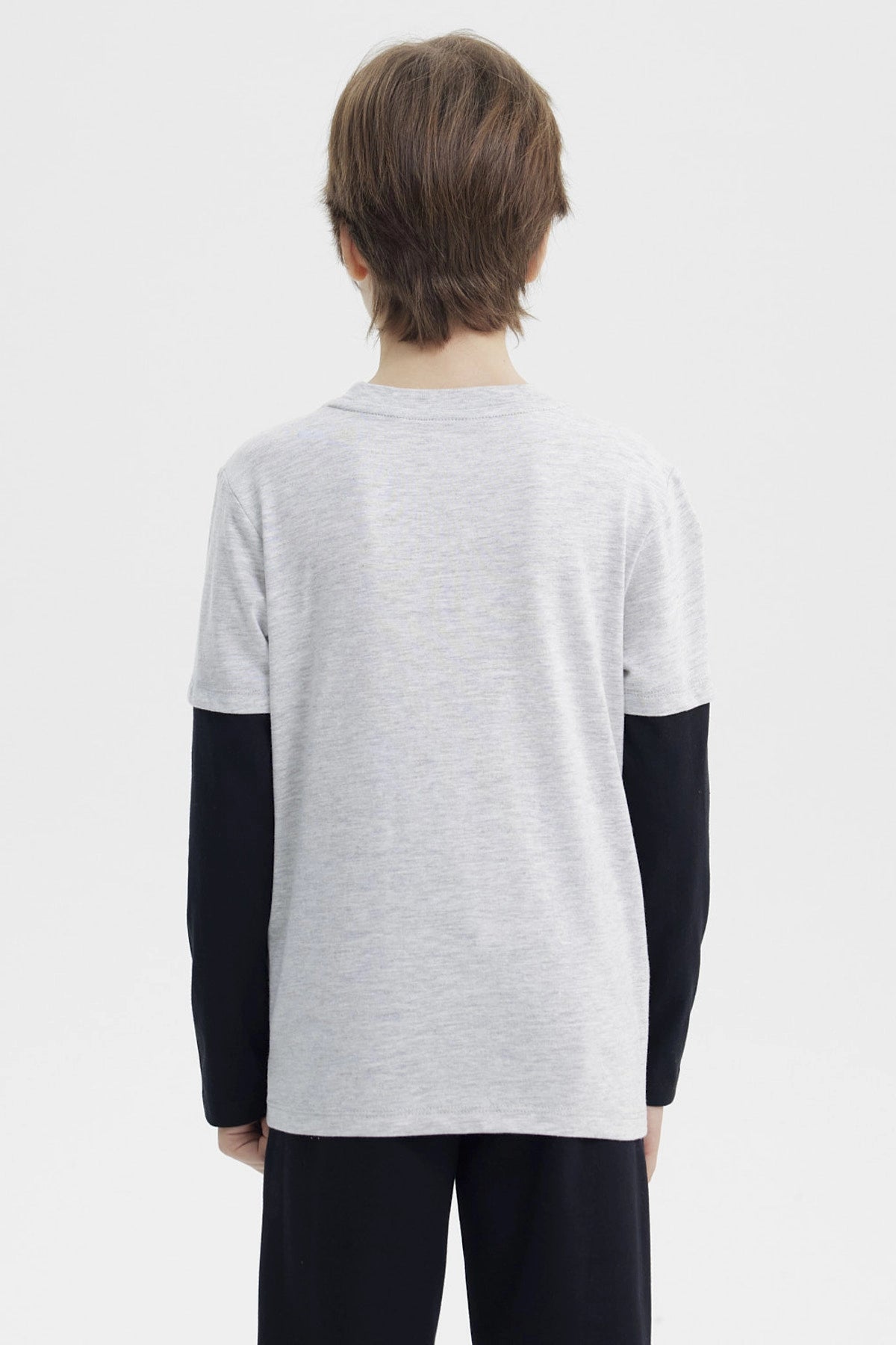 Polera niño gris melange claro con estampa central New York y personaje con balón en estilo gráfico animado