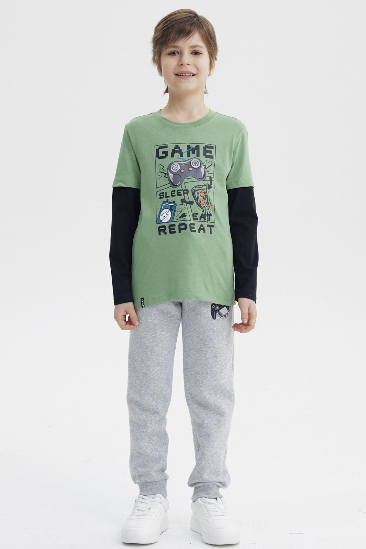 Polera niño verde claro con estampa central de videojuego con control consola pizza y texto GAME SLEEP EAT REPEAT