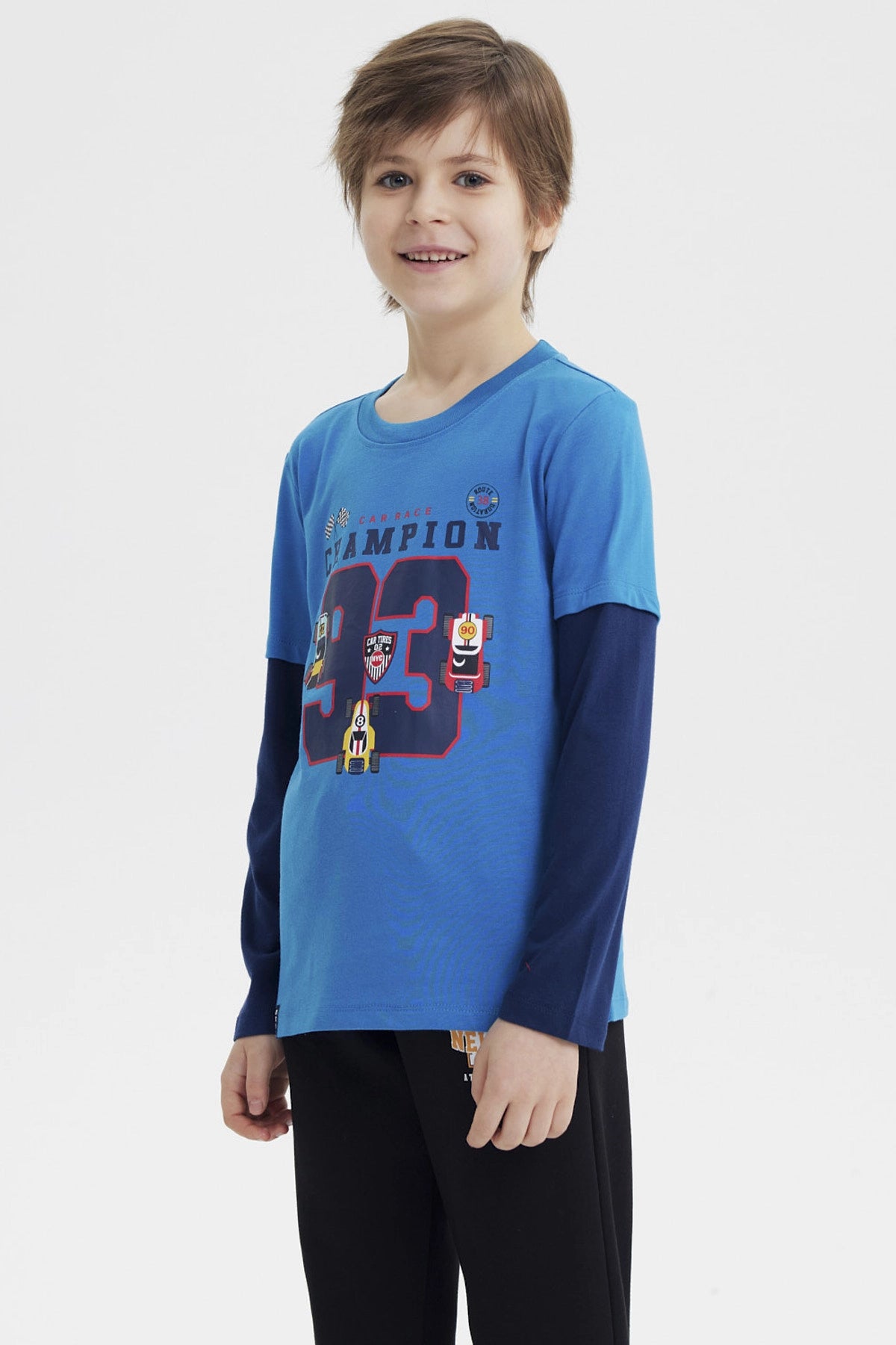 Polera niño azul petróleo con estampa de autos de carrera y texto Champion 93 en el pecho estilo deportivo y colorido