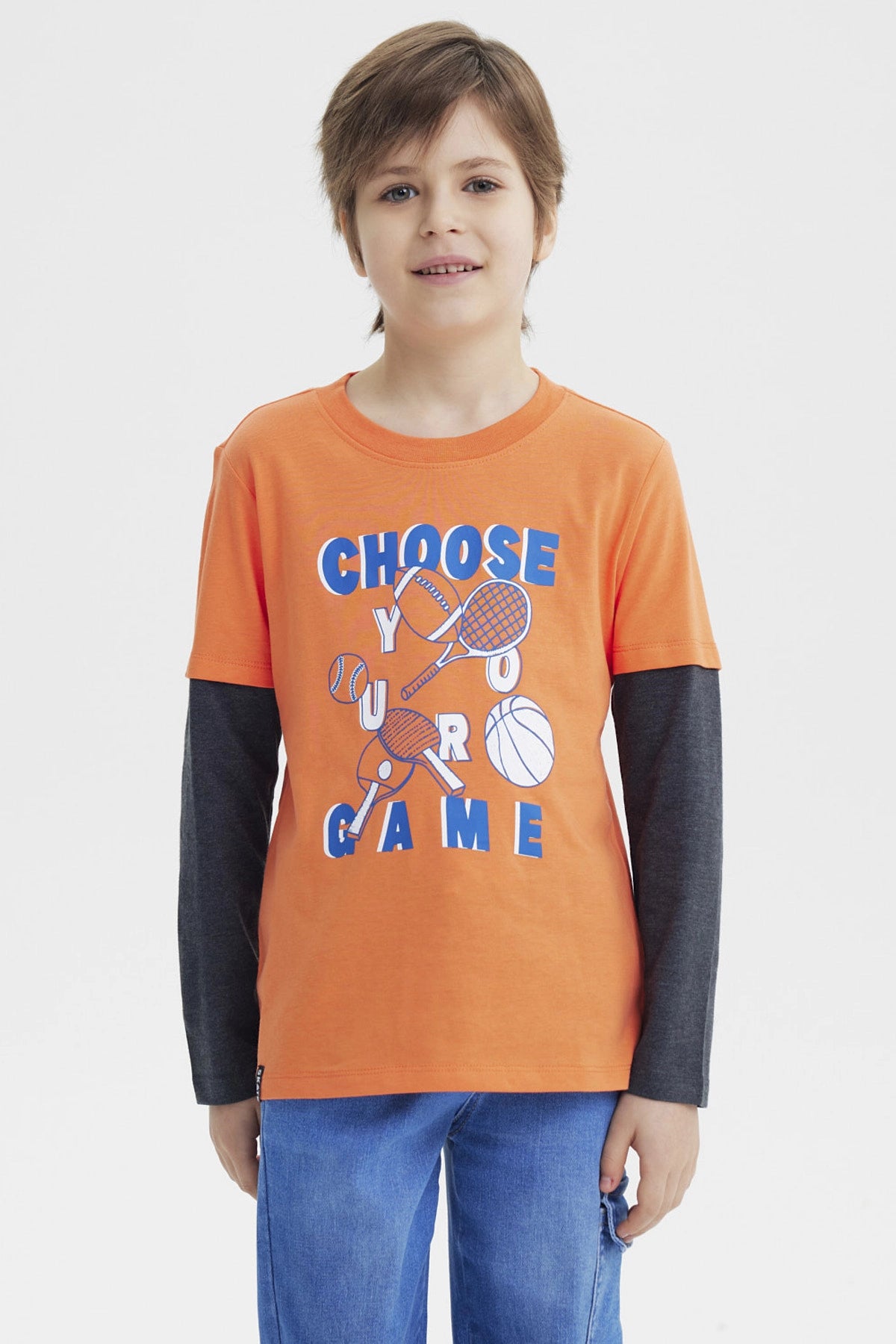 Polera naranja para niño con estampa deportiva al frente que dice Choose Your Game en azul y blanco diseño gráfico grande