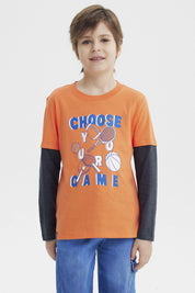 Polera naranja para niño con estampa deportiva al frente que dice Choose Your Game en azul y blanco diseño gráfico grande