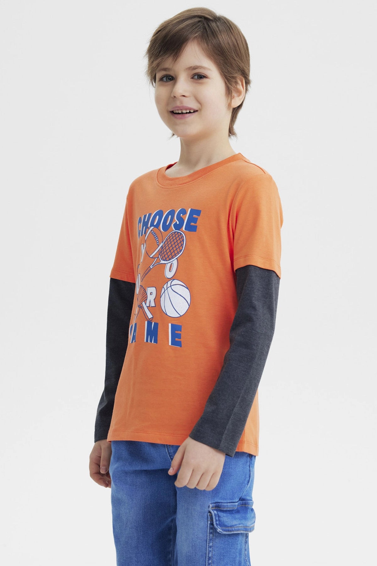 Polera naranja para niño con estampa deportiva al frente que dice Choose Your Game en azul y blanco diseño gráfico grande