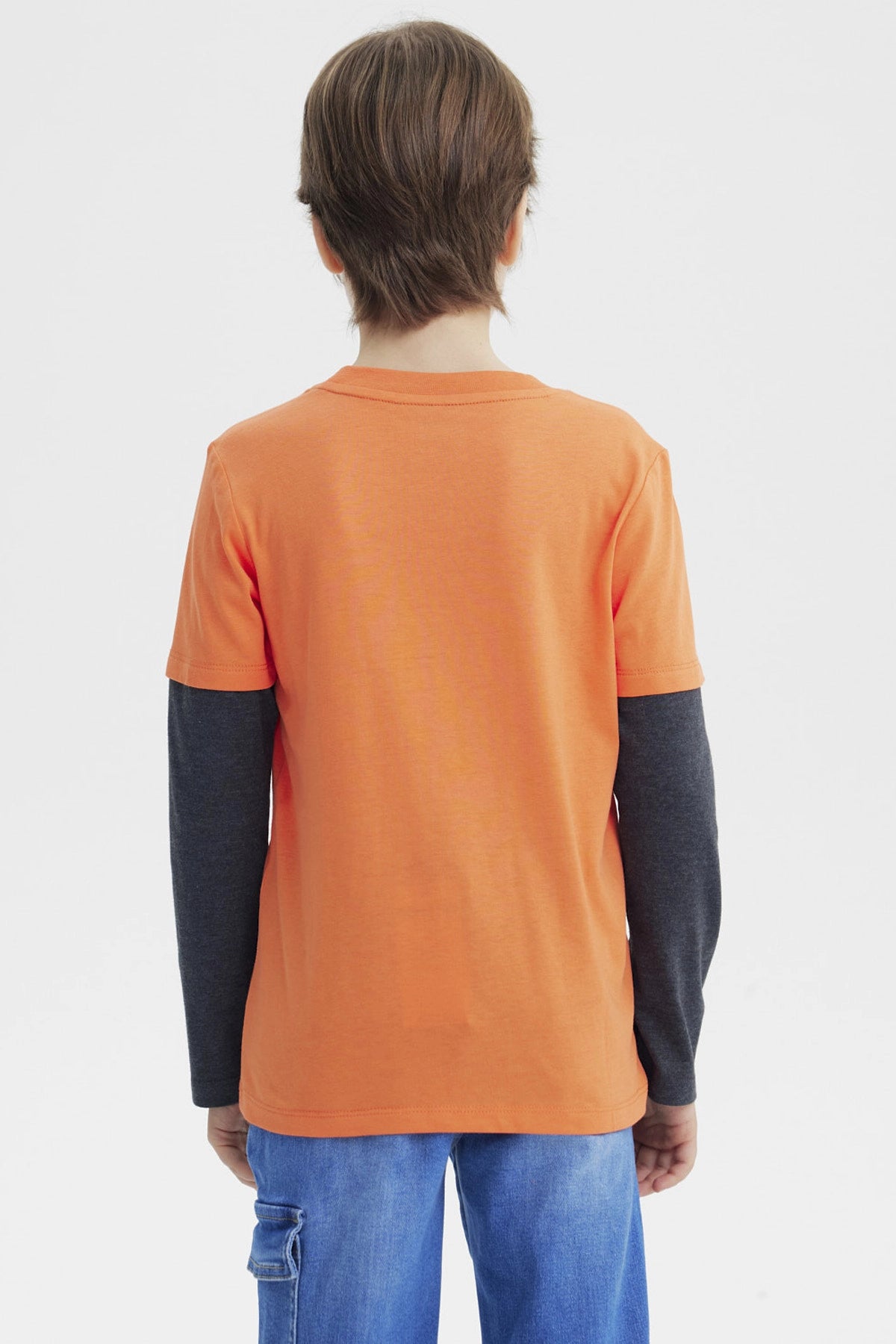 Polera naranja para niño con estampa deportiva al frente que dice Choose Your Game en azul y blanco diseño gráfico grande
